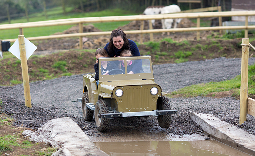 Mum and two kids on mini jeep at Avon Valley Adventure Park